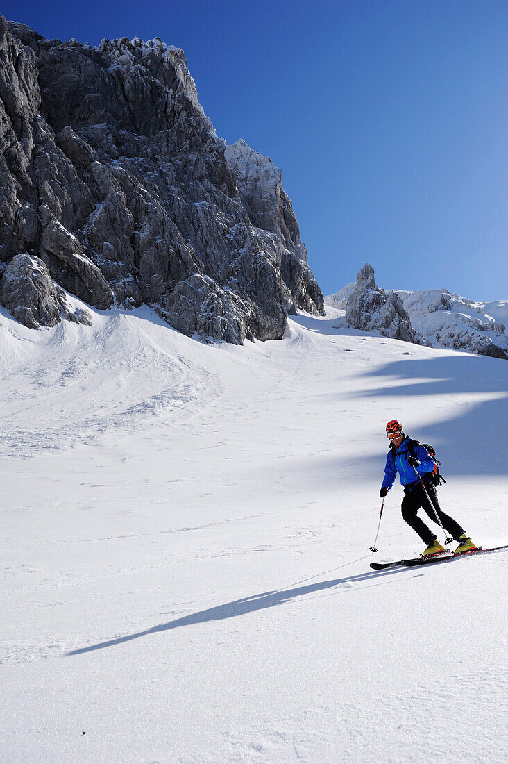 Man downhill skiing from Rote-Rinn-Scharte to cirque Hoher Winkel, Kaiser-Express, Wilder Kaiser, Kaiser mountain range, Tyrol, Austria