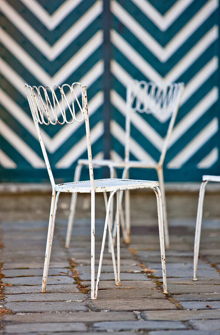 Two white garden chairs in front of the striped wall, Vienna, Austria
