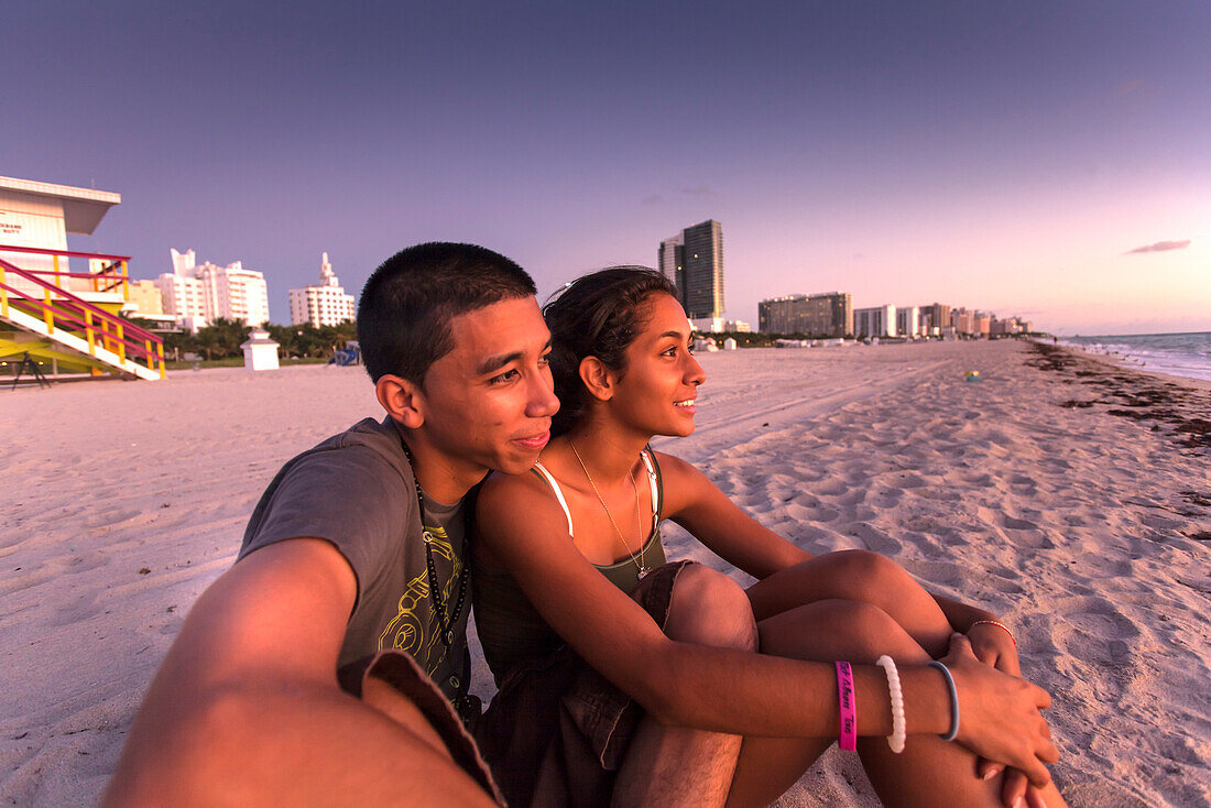 Junges Latino Päarchen beim Betrachten des Sonnenaufganges, South Beach, Miami, Florida, USA