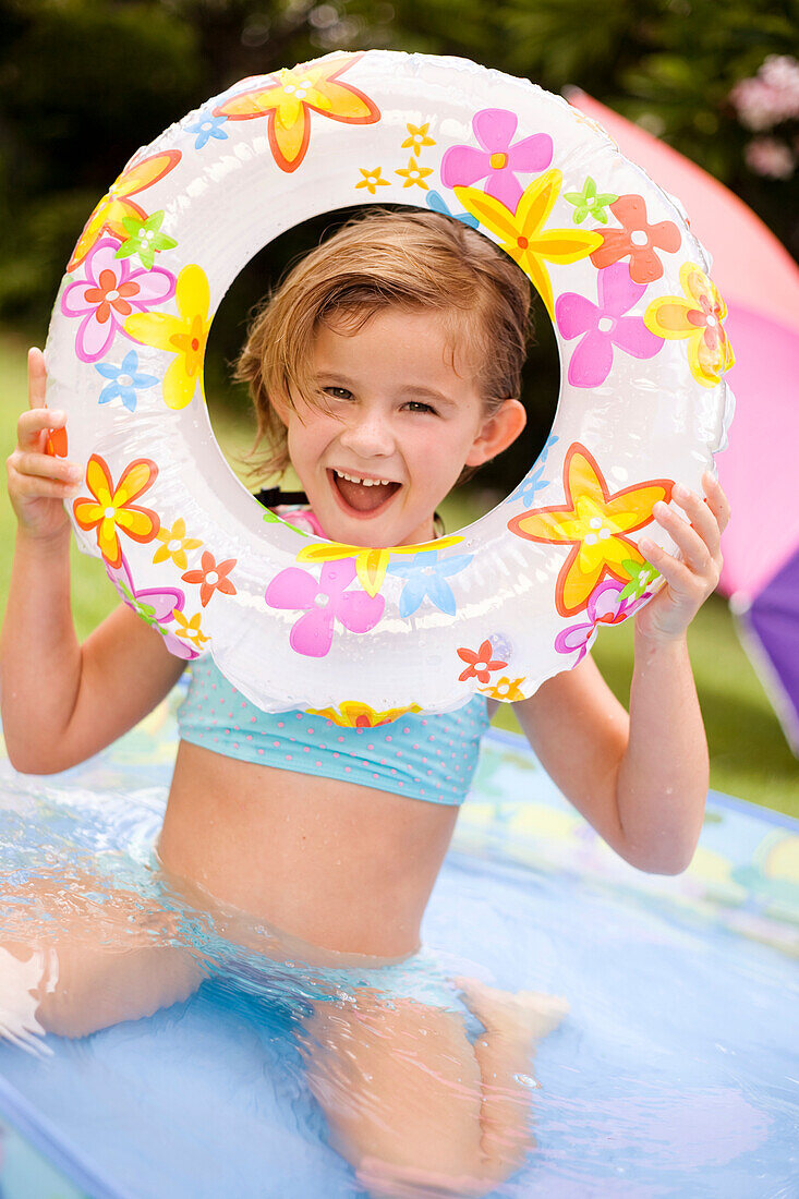 Hawaii, Oahu, Young girl playing in a pool with an innertube.