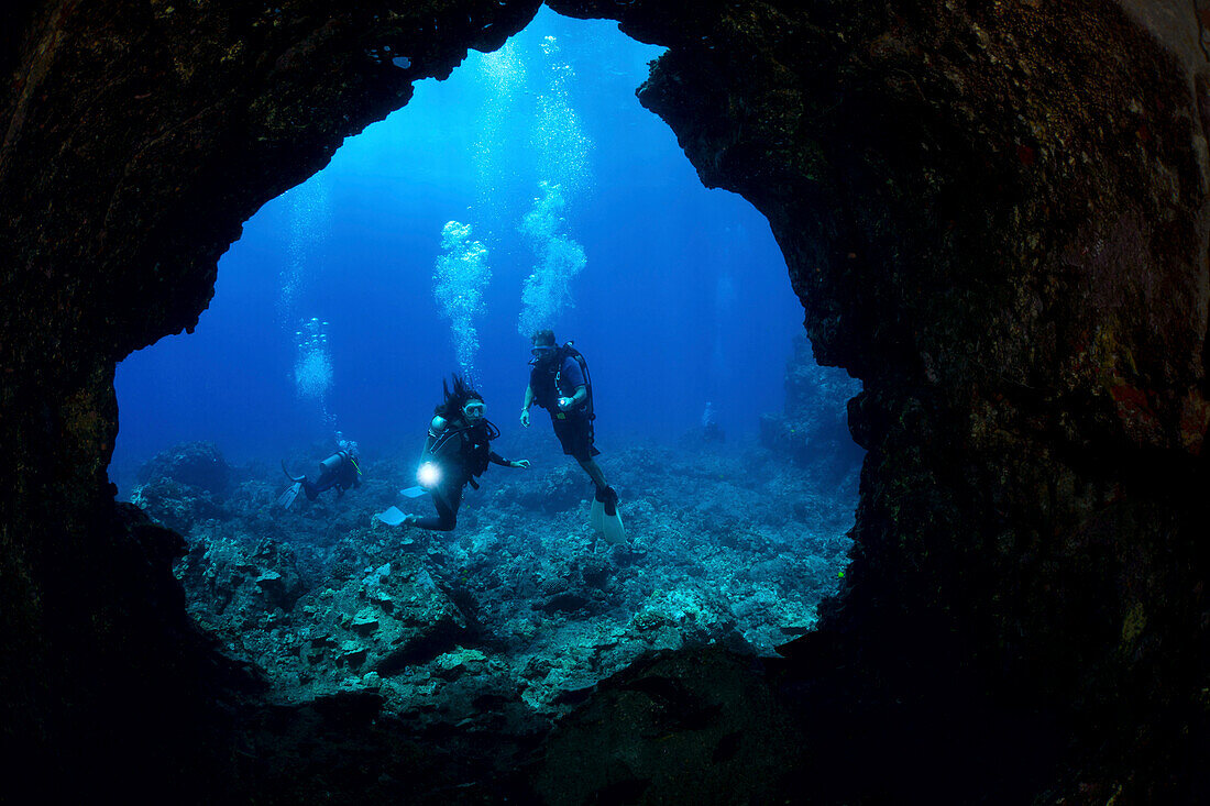 Hawaii, Lanai, Divers pictured at the entrance to a lava tube