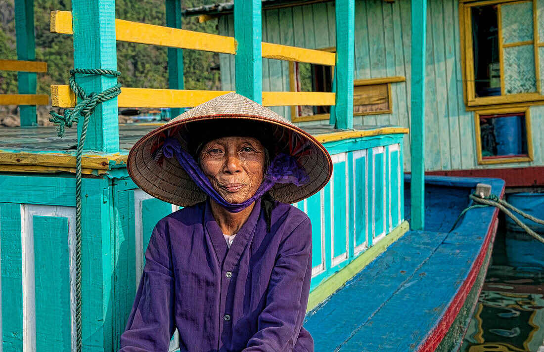 South East Asia, Vietnam, Ha Long Bay, Portrait of a Vietnamese woman sitting on docked fishing boat.