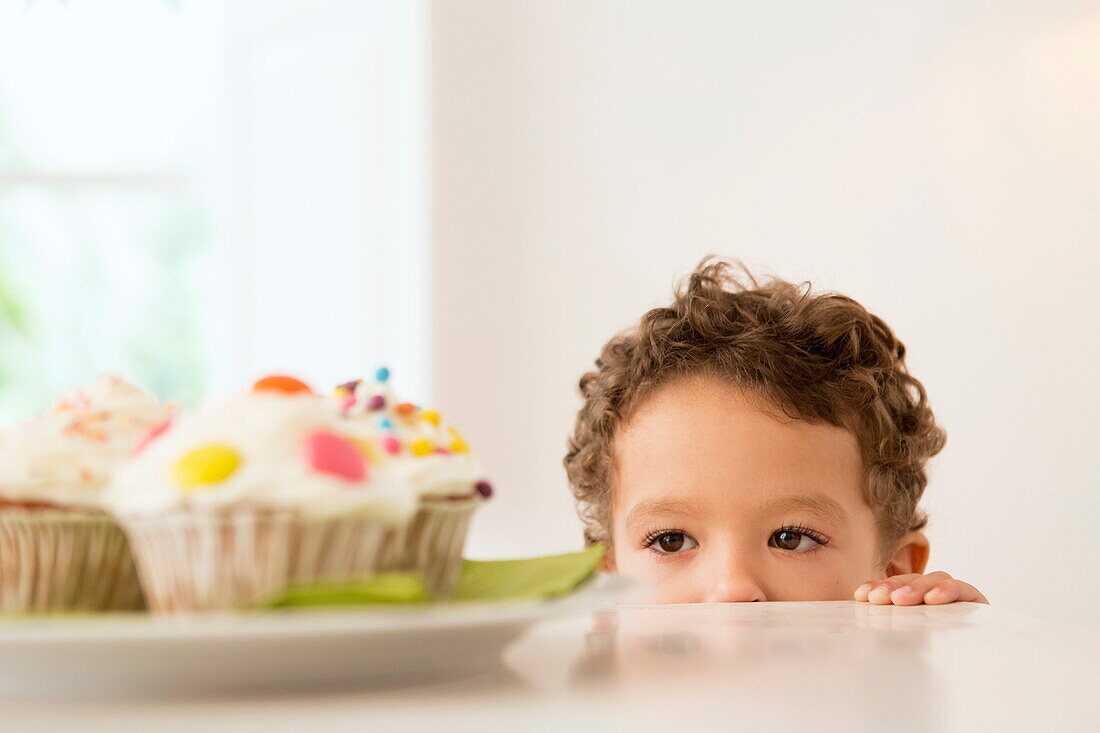 Four year old boy waiting for a cupcake