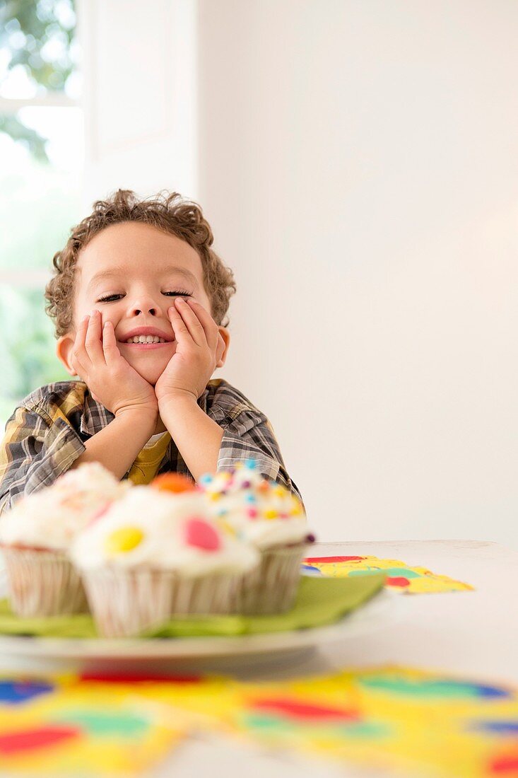 Four year old boy waiting for a cupcake