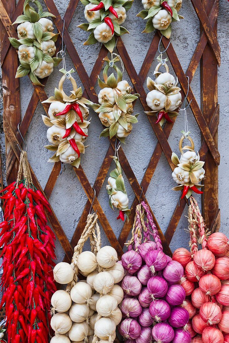 A closeup of dried onions and peppers at an outdoor shop in the village of Ravello, Italy