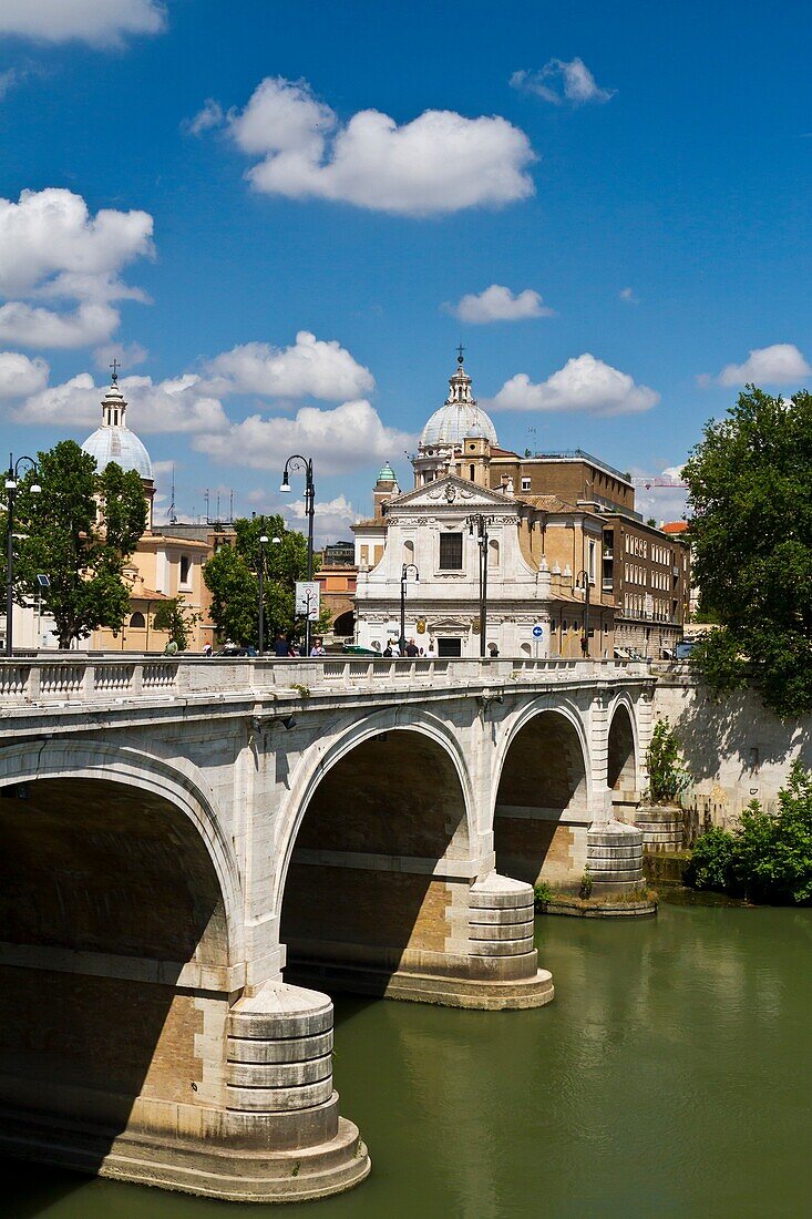 The city skyline with churches and a bridge over the Tiber River in Rome, Italy