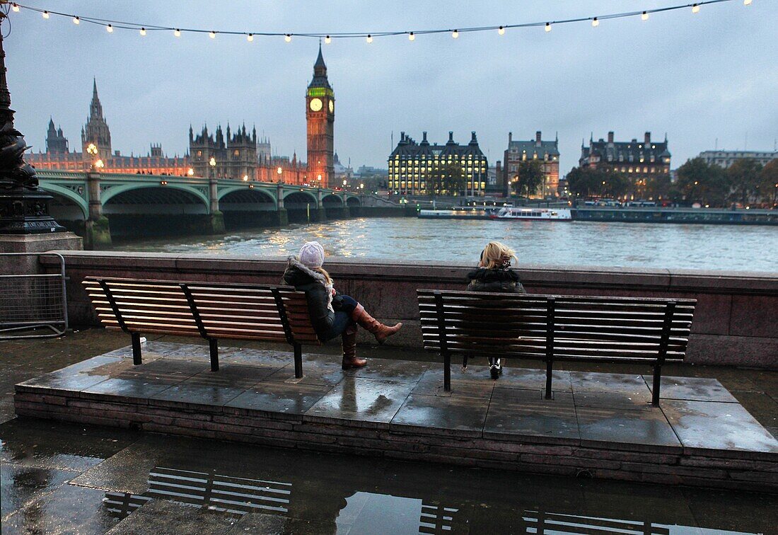 Women sitting and view of the Houses of Parliament, Westminster Bridge and The River Thames, London, England. Women sitting and view of the Houses of Parliament, Westminster Bridge and The River Thames, London, England