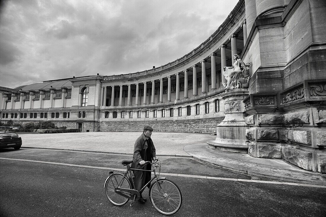 Man with bicycle in the Cinquantenaire triumphal arch in Brussels, Belgium