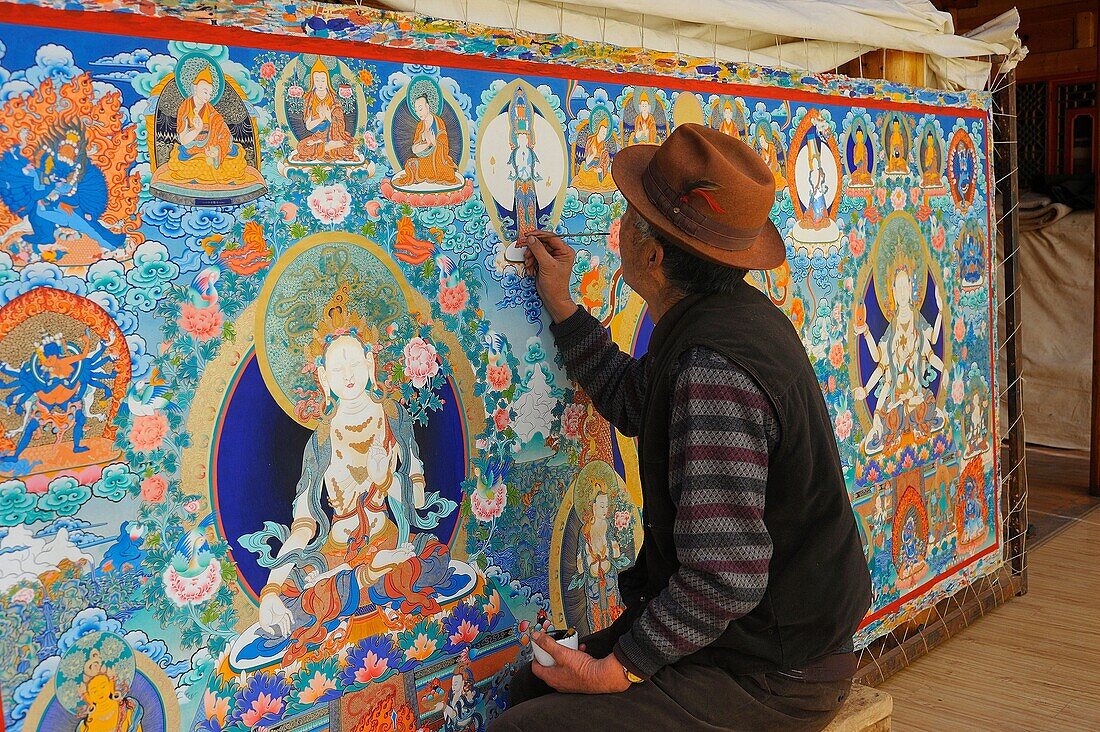 China, Qinghai, Amdo, Tongren Rebkong, Tibetan artist Tenzin Gyal painting a thangka