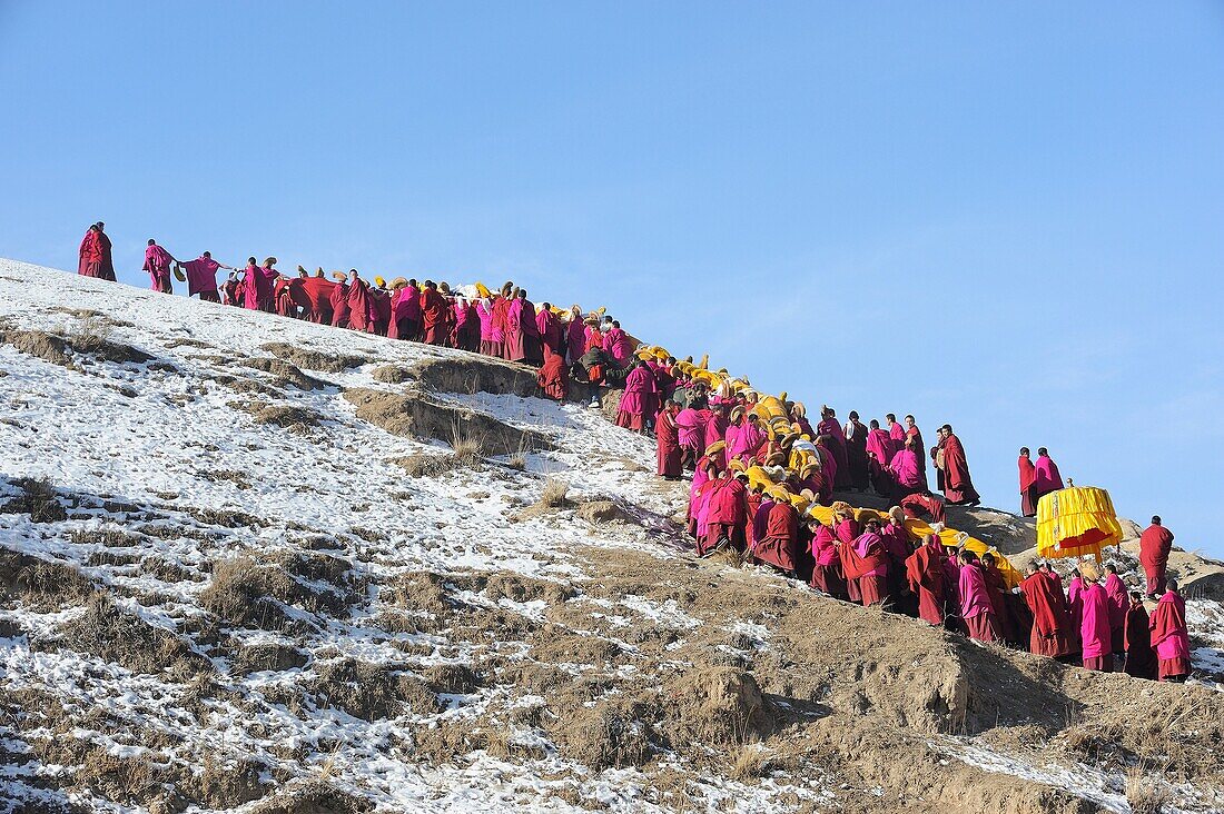 China, Gansu, Amdo, Xiahe, Monastery of Labrang Labuleng Si, Losar New Year festival, Giant Thangka bearers climbing uphill