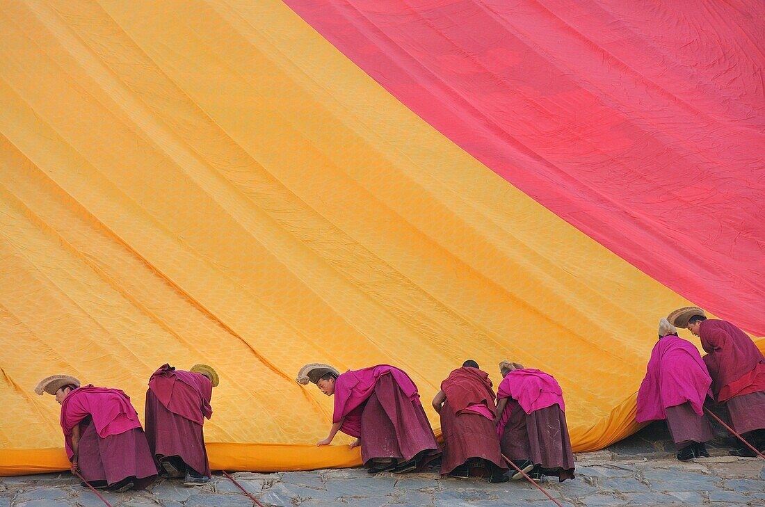 China, Gansu, Amdo, Xiahe, Monastery of Labrang Labuleng Si, Losar New Year festival, Monks unfurling the giant Thangka