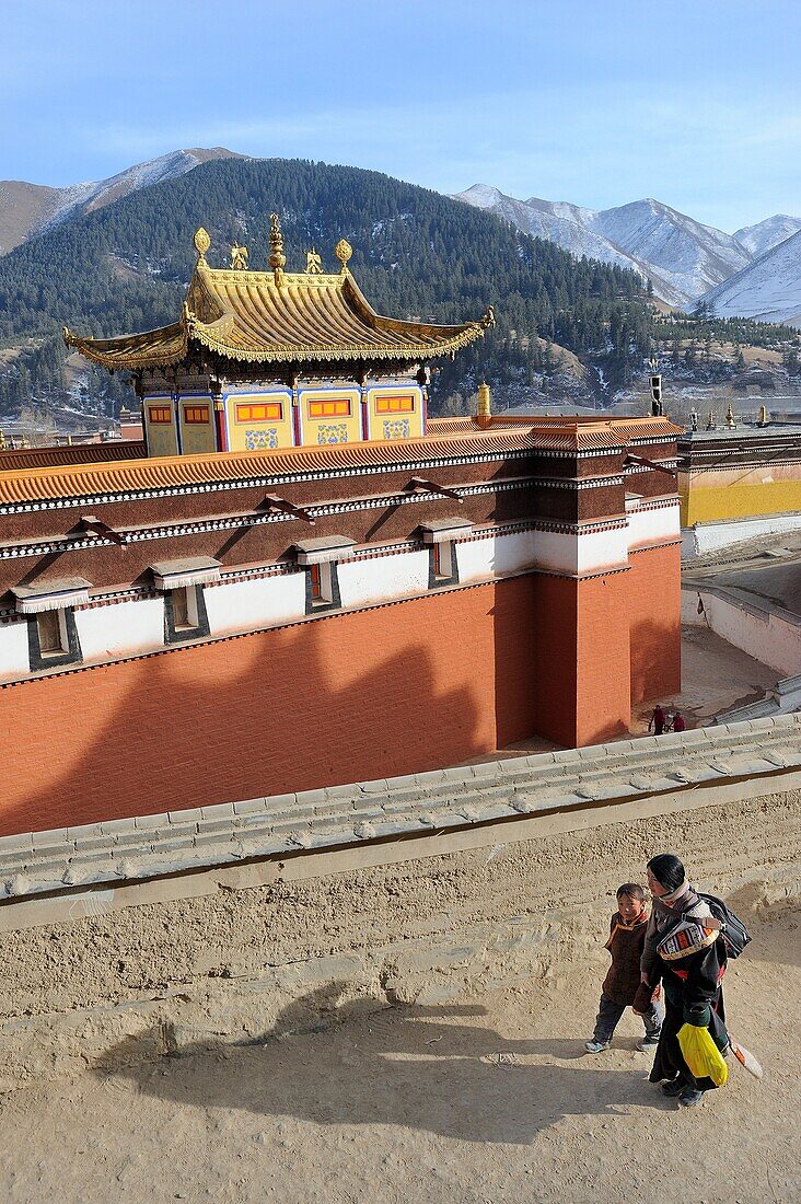 China, Gansu, Amdo, Xiahe, Monastery of Labrang Labuleng Si, Losar New Year festival, Tibetan pigrim and child doing the kora circumambulation around the monastery