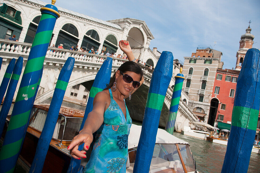 Young Woman possing for a photo in front of the rialto bridge, Grand Canal, Venice, Venezia, Italy, Europe