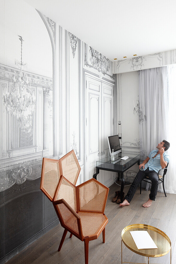 Mann sitzt am Schreibtisch in einer Suite, Hotel La Maison Champs-Elysees, Paris, Frankreich