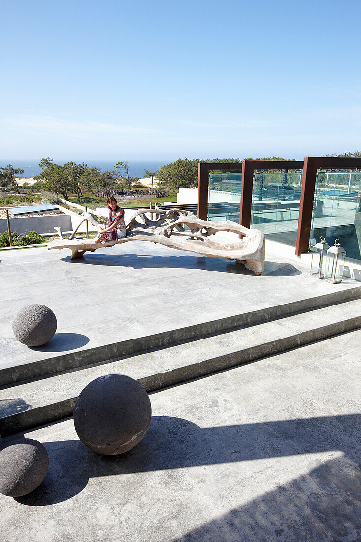 Frau auf der Dachterrasse mit Skulptur aus Treibholz und Blick aufs Meer, Hotel Areias do Seixo, Povoa de Penafirme, A-dos-Cunhados, Costa de Prata, Portugal
