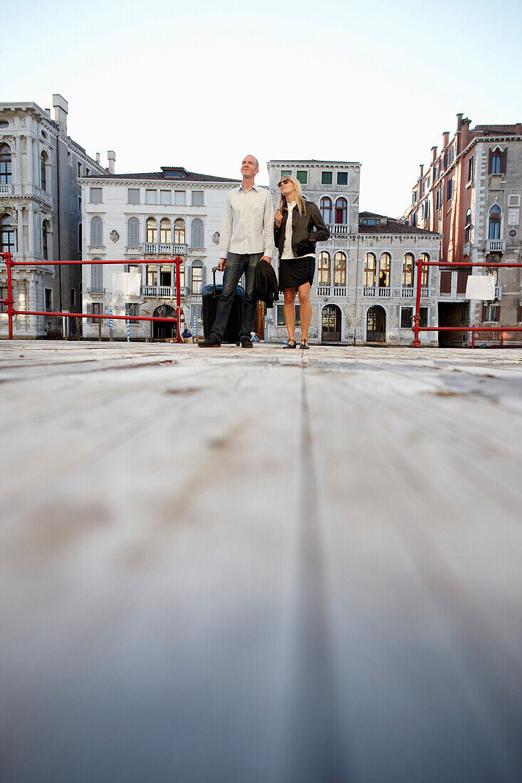 Paar mit Trolley auf einem Ponton im Canal Grande, Eingang zur Krug Lounge im Hotel Palazzina Grassi, Venedig, Venetien, Italien