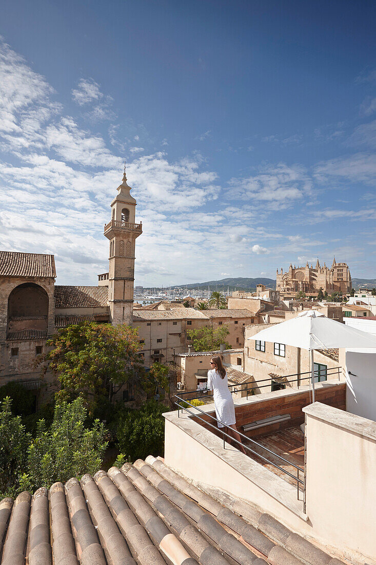 Woman enjoying view to Santa Clara convent from a hotel roof deck, Palma de Mallorca, Mallorca, Balearic Islands, Spain