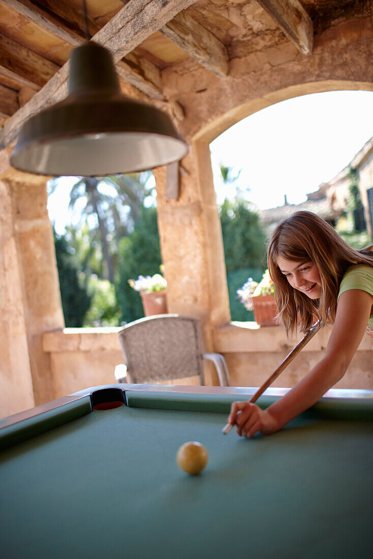 Mädchen spielt Billard auf überdachter Terrasse, Finca Raims, Algaida, Mallorca, Balearische Inseln, Spanien