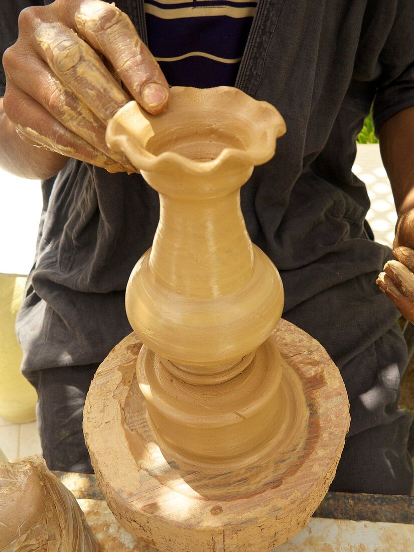 Tunisian potter using clay to make a candlestick, Djerba, Tunisia