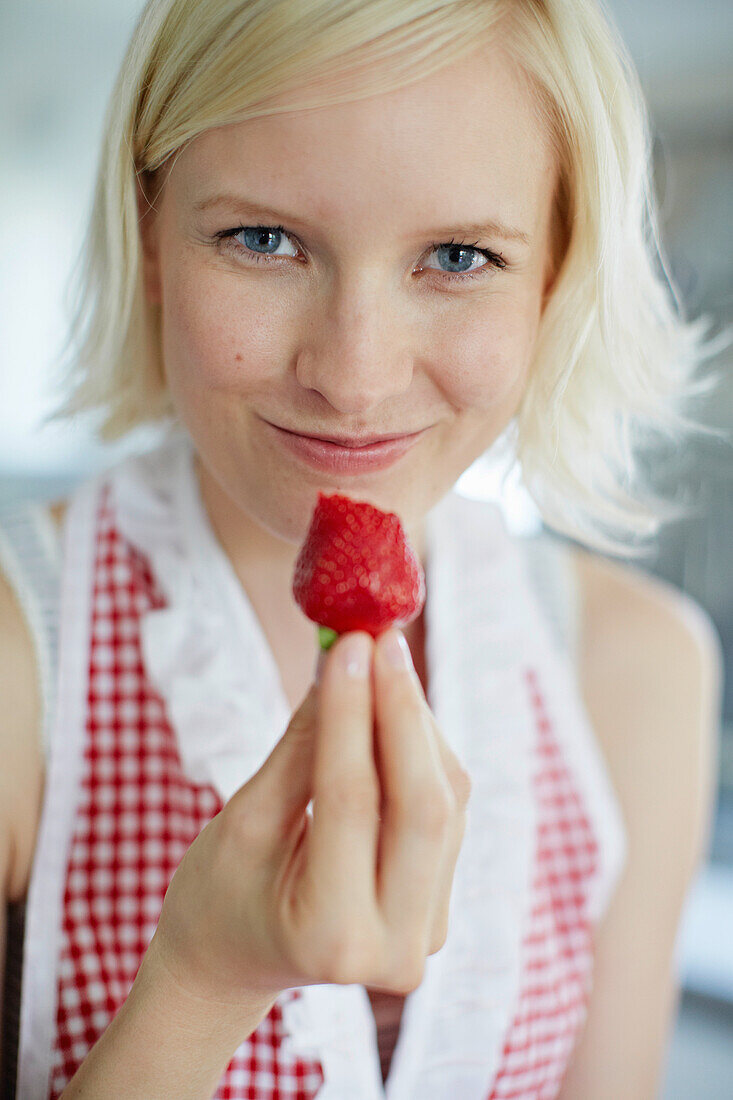 Close up of woman eating strawberry