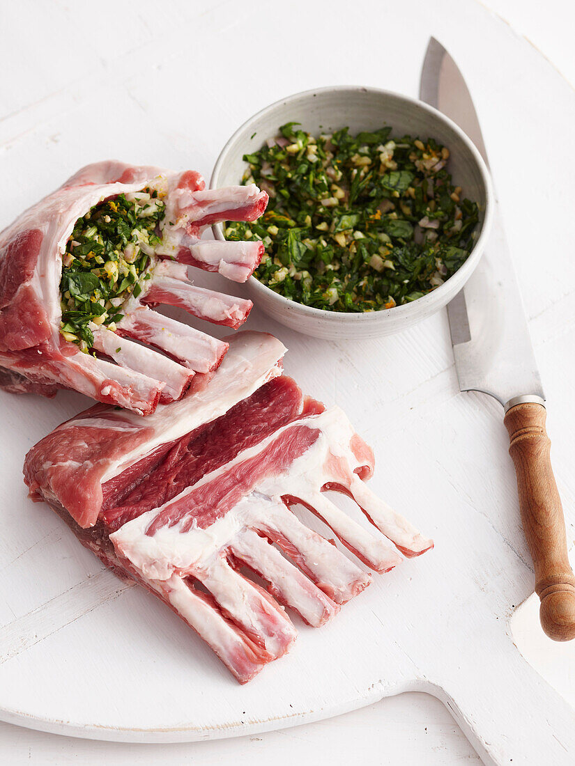 Raw lamb racks stuffed with herbs. Roast Lamb Step _ Spinach+Pinenut Stuffing mix