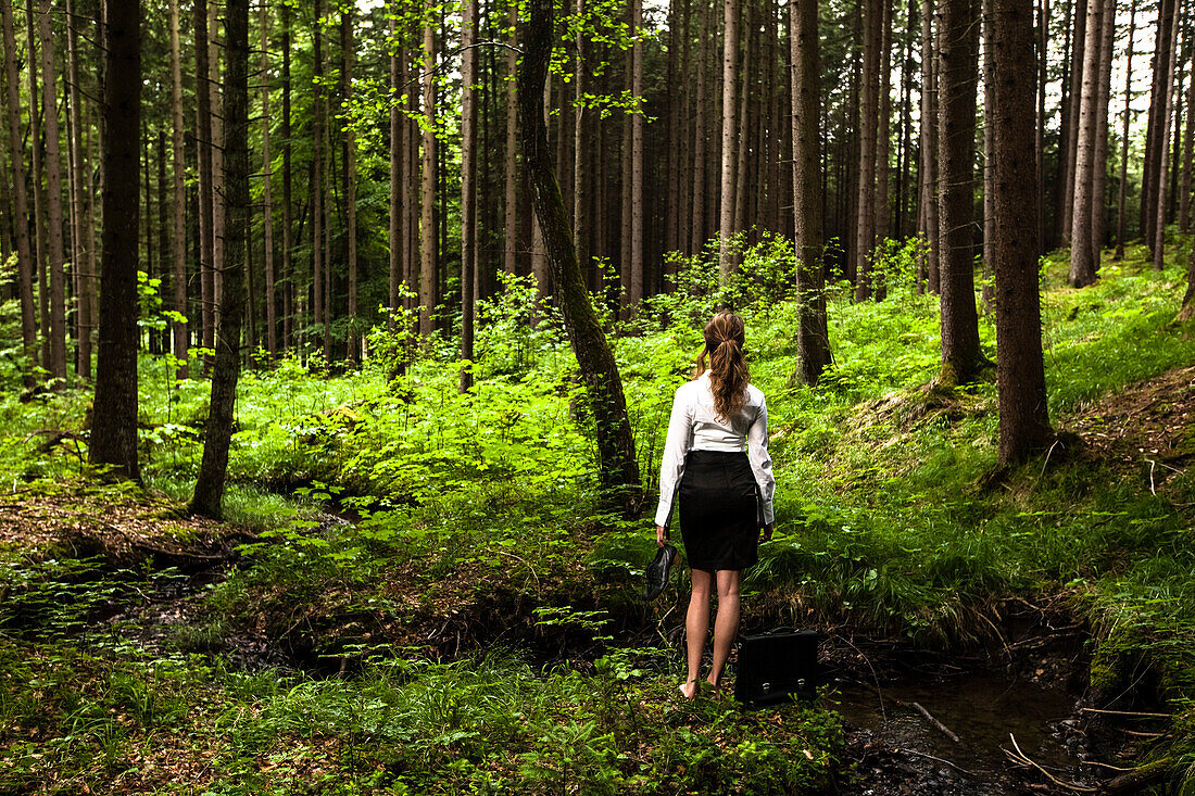 Young woman wearing business suit in a forest, Bavaria, Germany