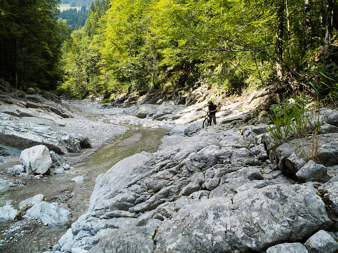 Mountain biker near creek bed, Karwendel, Bavaria, Germany