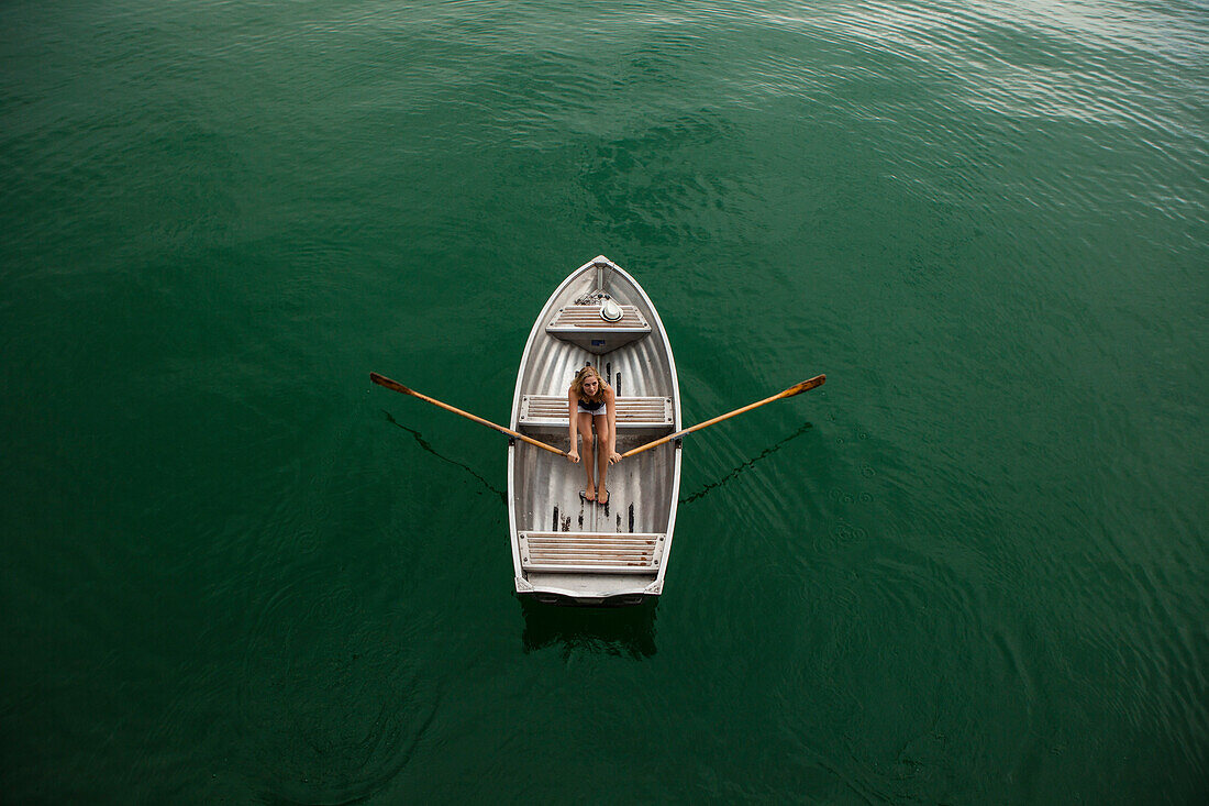 Junge Frau in einem Ruderboot auf dem Starnberger See, Bayern, Deutschland