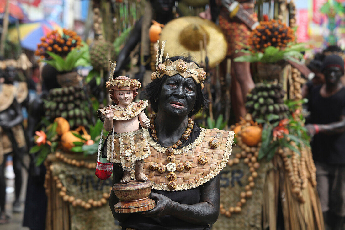 Old woman holding a Santo Nino figur, Ati Atihan Festival, Kalibo, Aklan, Western Visayas Region, Panay Island, Philippines