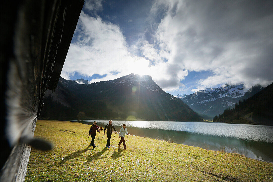 Three Nordic Walkers at lake Vilsalpsee, Tannheim, Tannheim Valley, Tyrol, Austria