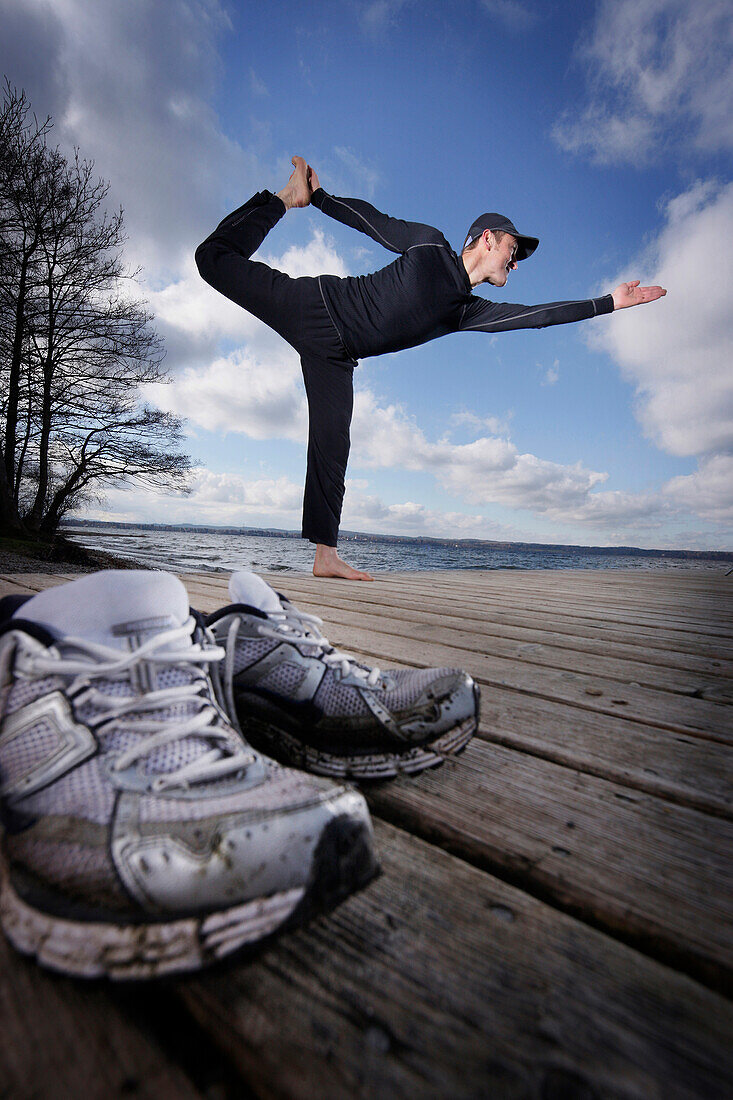 Läufer macht Yogaübungen, Ambach, Münsing, Bayern, Deutschland