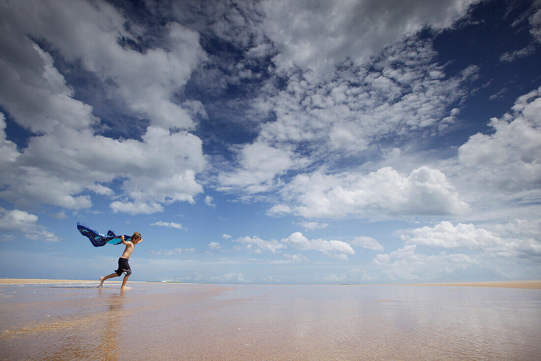 Junge läuft mit einem Tuch über Lagune, Tangalle, Hambantota, Südprovinz, Sri Lanka