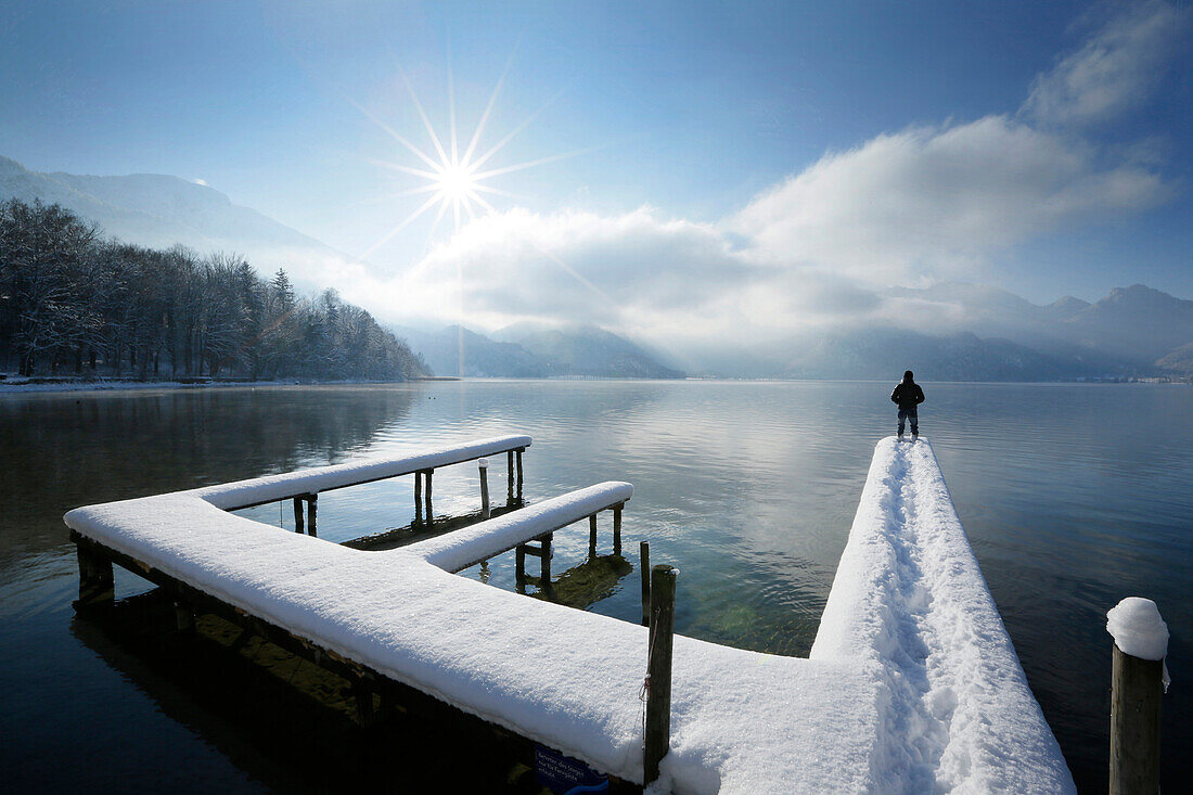 Man standing on snow-covered jetty at lake Kochel, Upper Bavaria, Germany