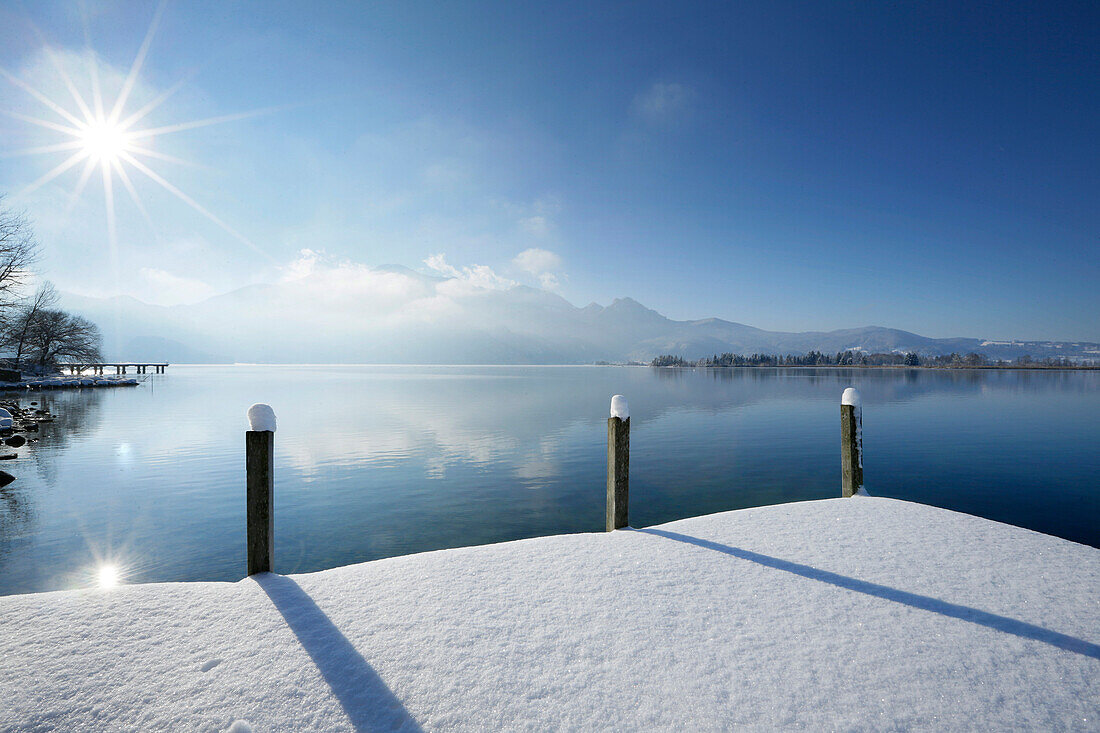 Snow-covered jetty at lake Kochel, Kochel, Bavaria, Germany