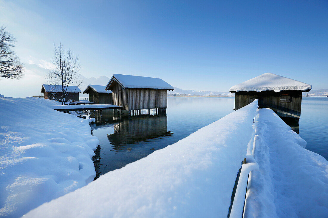 Snow-covered boathouses at lake Kochel, Upper Bavaria, Germany