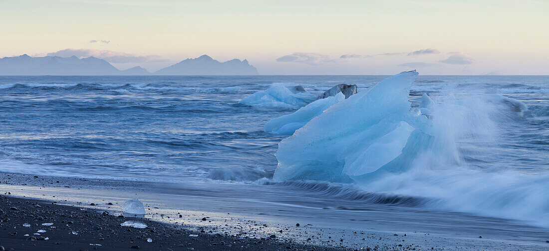 Eisberge in den Wellen bei der Gletscherlagune Jökulsárlon, Ostisland, Island