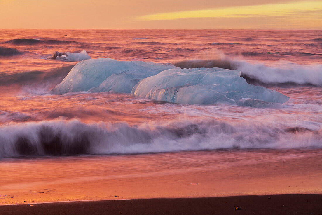 Eisberge in den Wellen bei der Gletscherlagune Jökulsárlon, Ostisland, Island