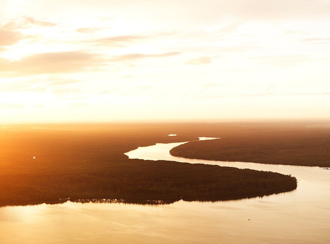 Aerial image of a tributary snaking through the jungle at sunset