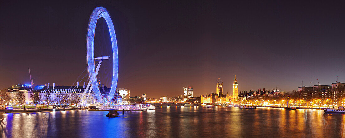 Panorama of the City of London with view from the Hungerford Bridge over the Thames towards the London Eye, Big Ben and Westminster Palace at night, England, United Kingdom