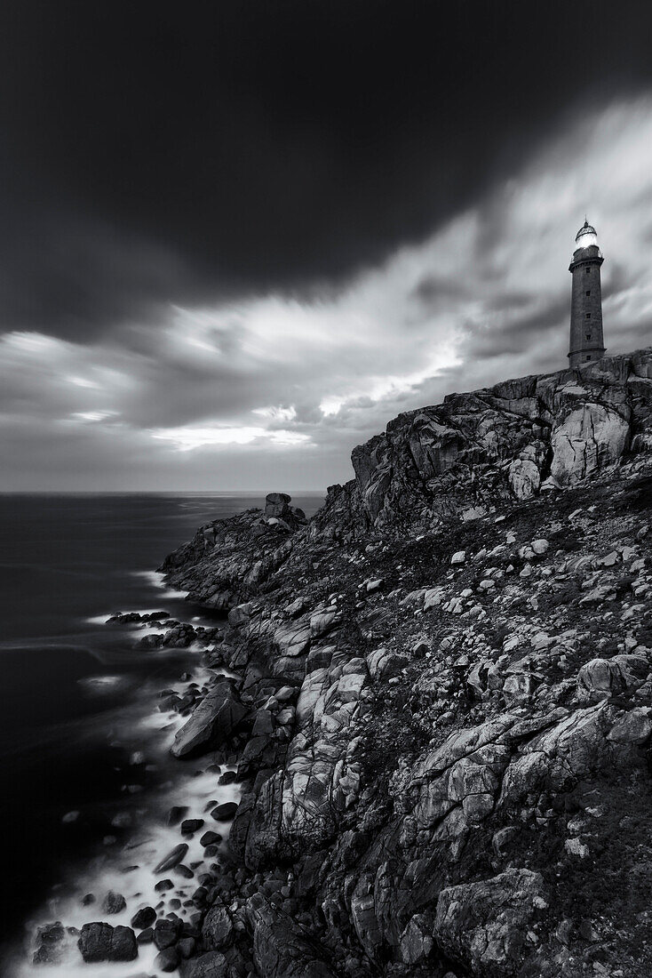 Schwarz-Weiß Aufnahme des Leuchtturms Cabo Vilan über dem Kap an der Costa da Morte, der rauen Küste Nordspaniens, Galicien, Spanien