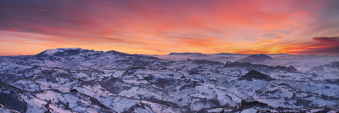 Sunset above the snow-covered hills of Italy’s southern Emilia-Romagna region and the peaks of the Etruscan Apennine Mountains, Emilia-Romagna, Italy