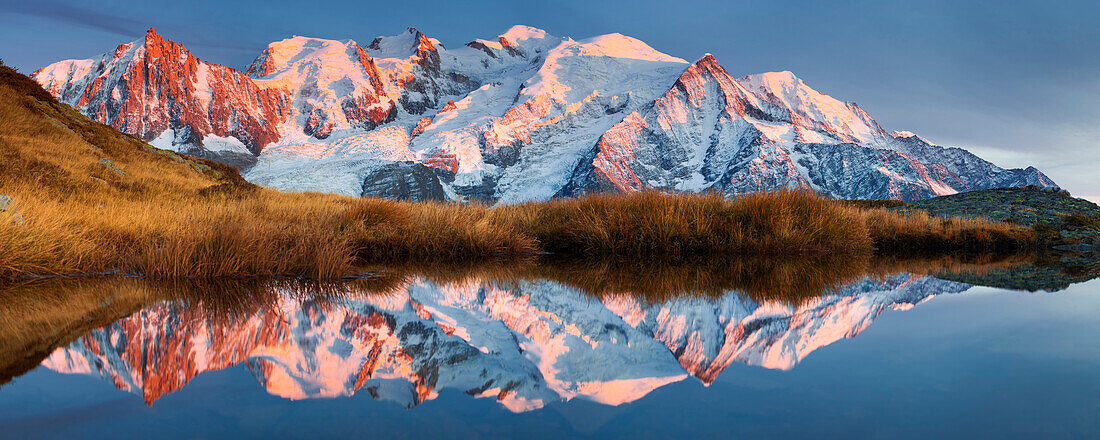 Alpen glow at the Mont Blanc Massif and its reflection in a mountain lake not far from the summit of Aiguillette du Brevent, Chamonix Valley, Haute-Savoie, France