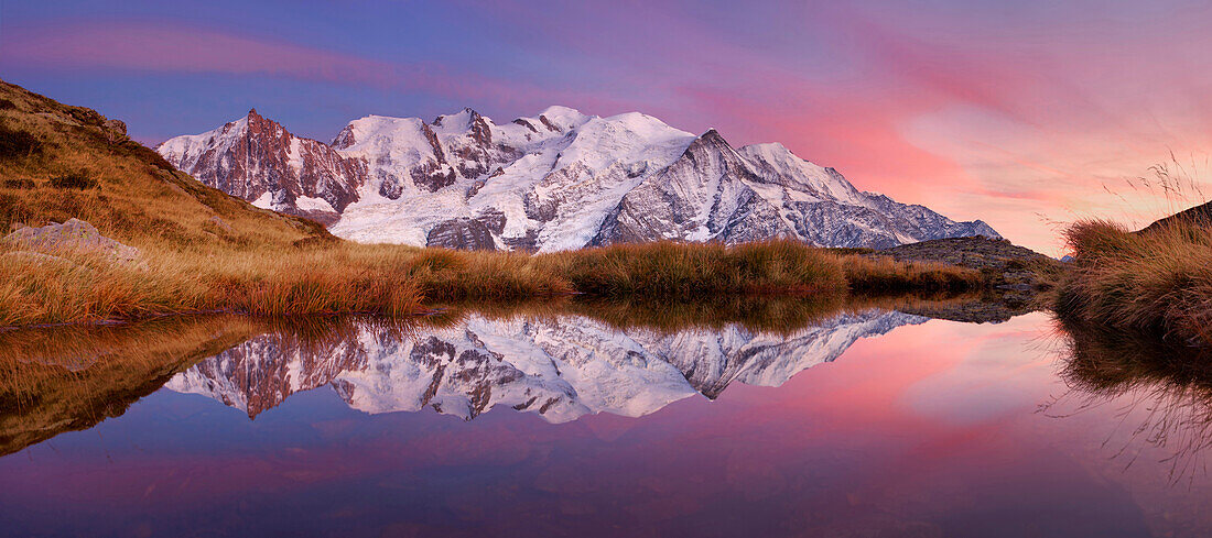 Sunset above the Mont Blanc Massif and its reflection in a small mountain lake not far from the summit of Aiguillette du Brevent, Chamonix Valley, Haute-Savoie, France