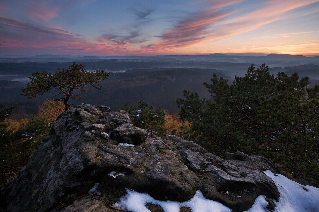 Sunset over the Bohemian Switzerland with a wide view to Zschirnstein in late autumn with first snow in the foreground, Usti nad Labem, Czech Republic