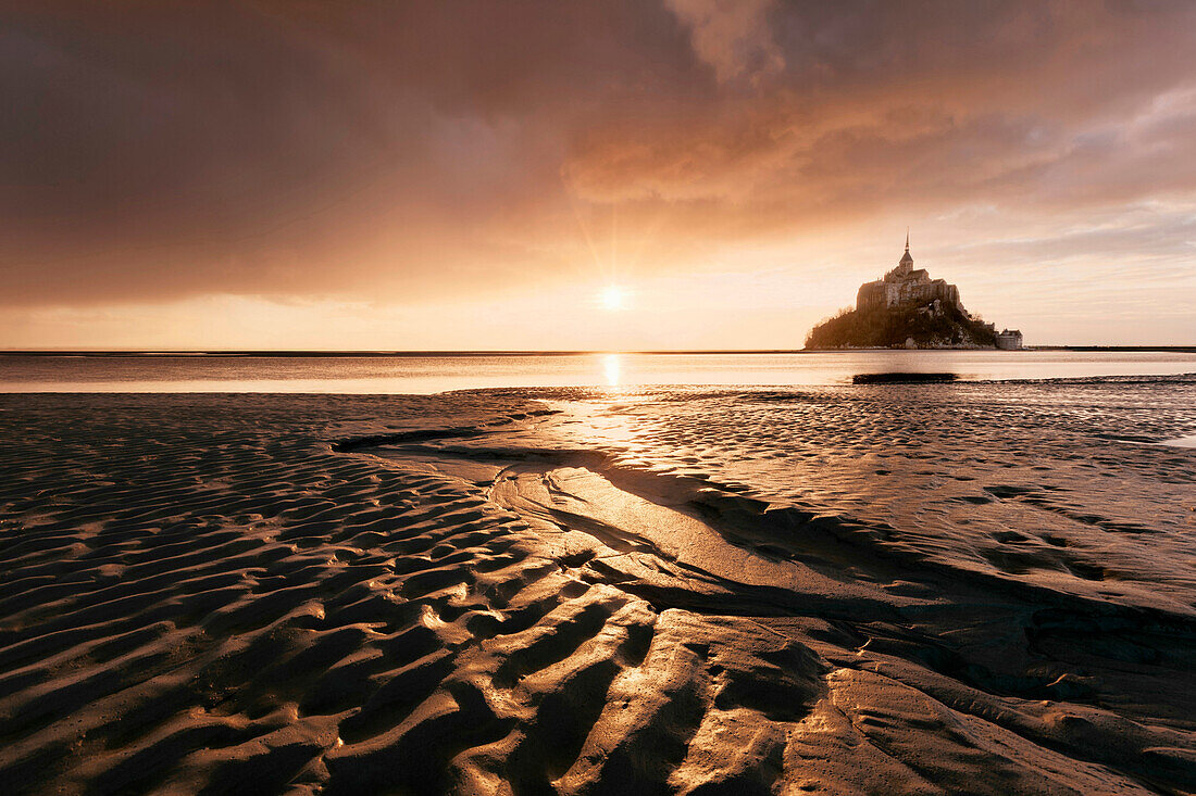 Impressive sunset above the famous monastery Mont-Saint Michel, built in the 10th century, Mont-Saint Michel with tide flat in the foreground, Normandy, France