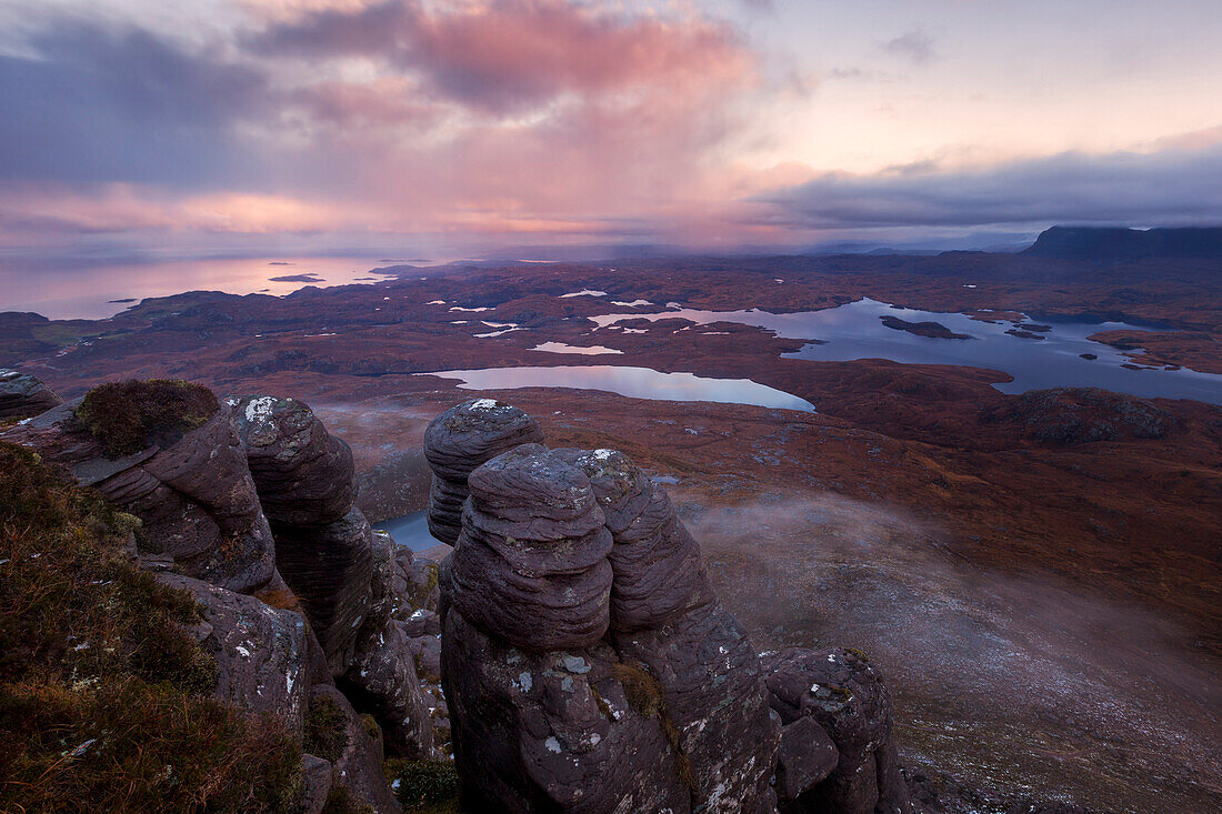 Sunrise with the view from Stac Pollaidh over the Inverpolly Nature Reserve with typical sandstone formations in the foreground, Sutherland, Scotland, United Kingdom