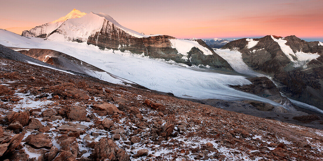 Blick vom Barrhorn auf den Sonnenaufgang über dem Brunegggletscher und den Gipfeln der Weißhorngruppe im Herbst, Wallis, Schweiz