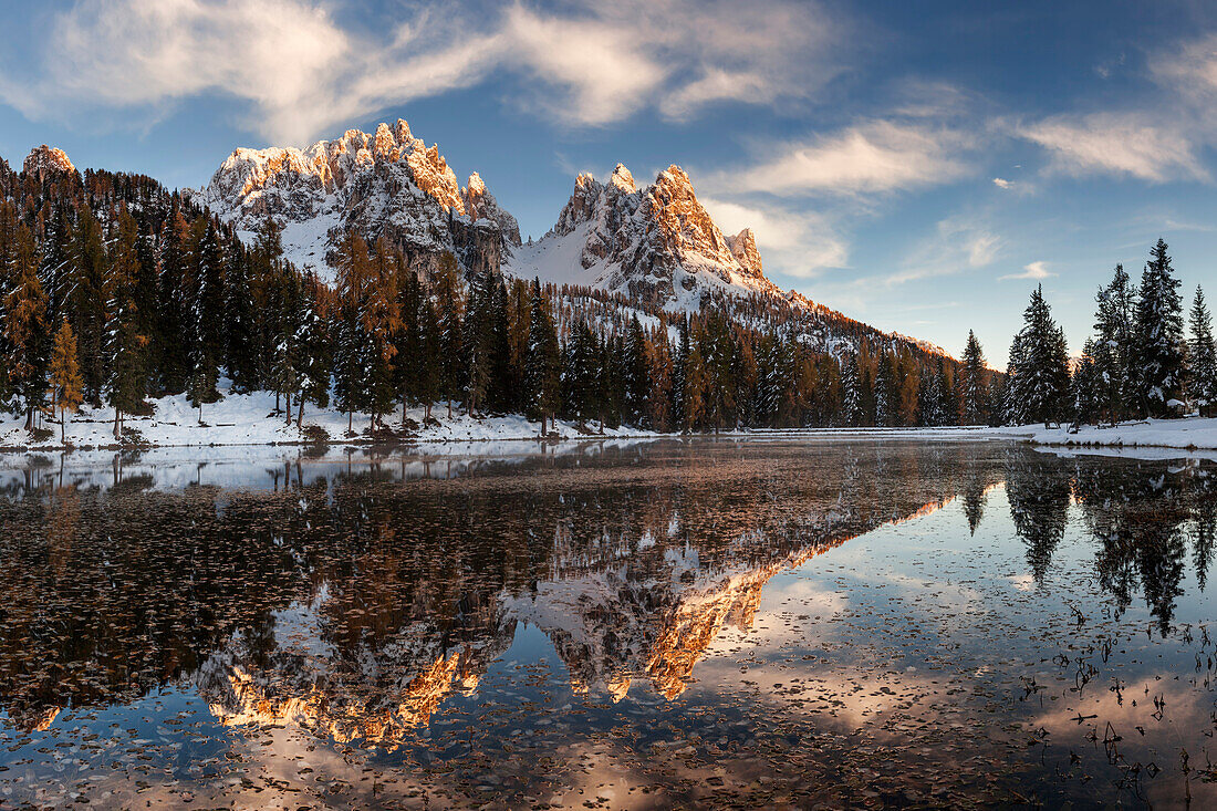 Picturesque sunset above the mirror-like Lago de Antorno with the numerous peaks of Cadini Misurina in the background, South Tyrol, Italy
