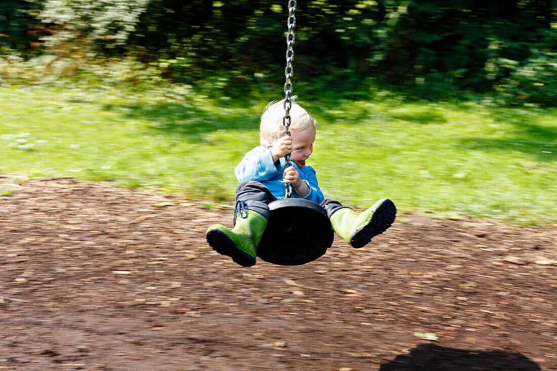 Junge (2 Jahre) auf einer Spielplatz Seilbahn, Leipzig, Sachsen, Deutschland
