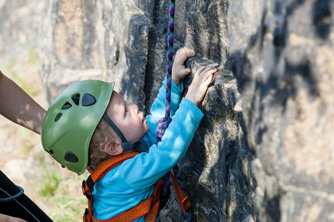 Junge (2 Jahre) beim Klettern in einem Steinbruch, Leipzig, Sachsen, Deutschland